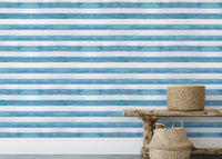 Minimalist decor with wooden bench and striped blue wallpaper.