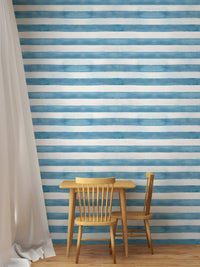 Kids play table with chairs and horizontal striped blue wallpaper.