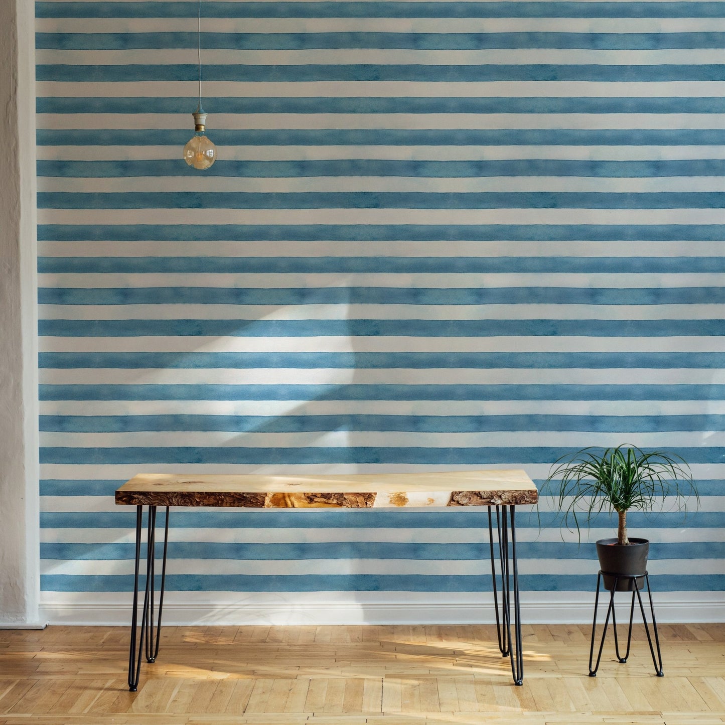 Wooden table and chair against a horizontal striped blue wallpaper.