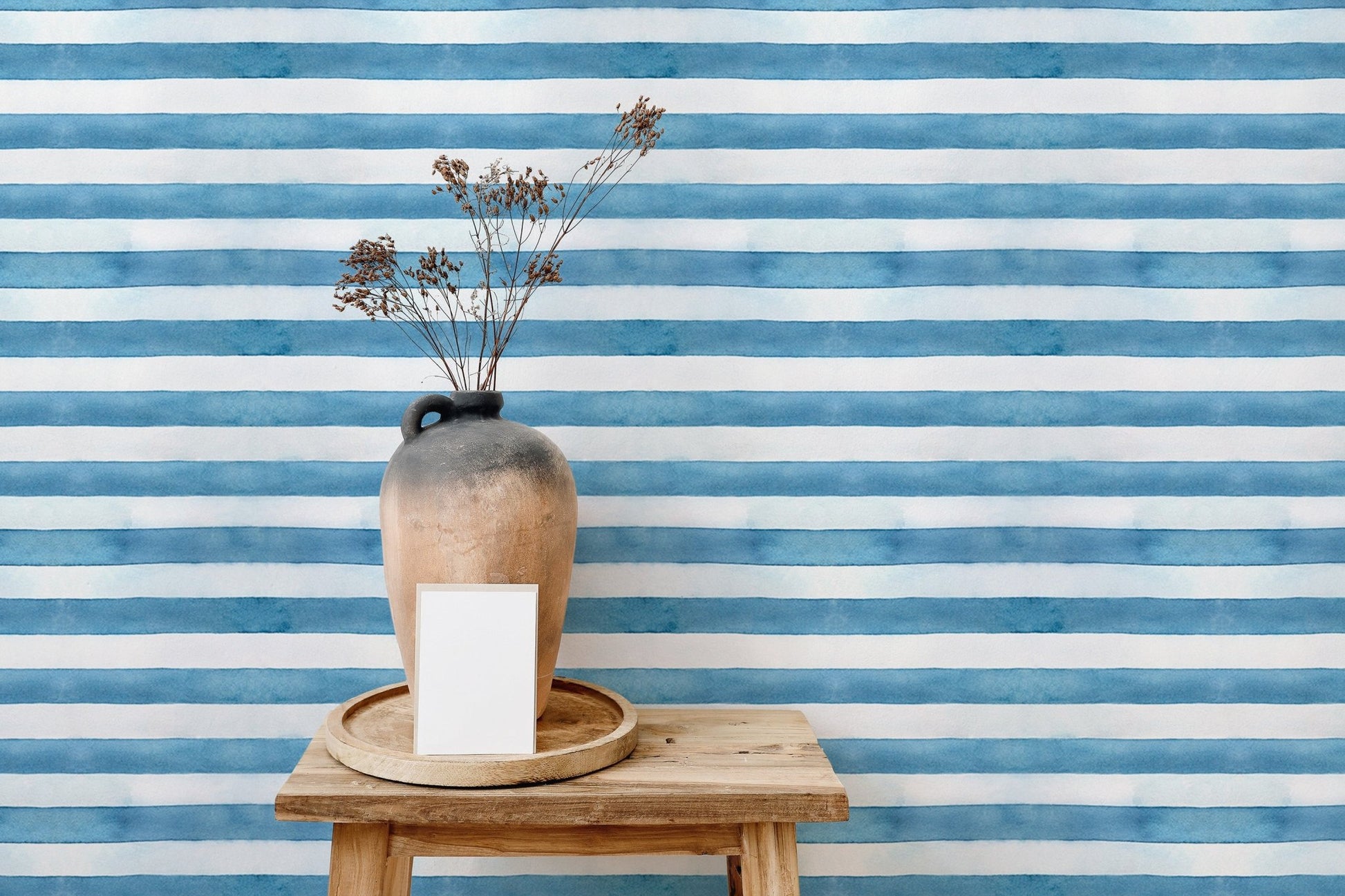 Small wooden table and vase near horizontal blue stripe wallpaper.