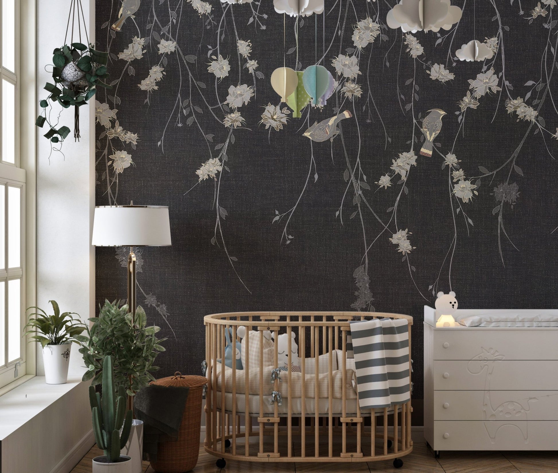 Nursery room with dark black flowers & birds wall mural and wooden crib.