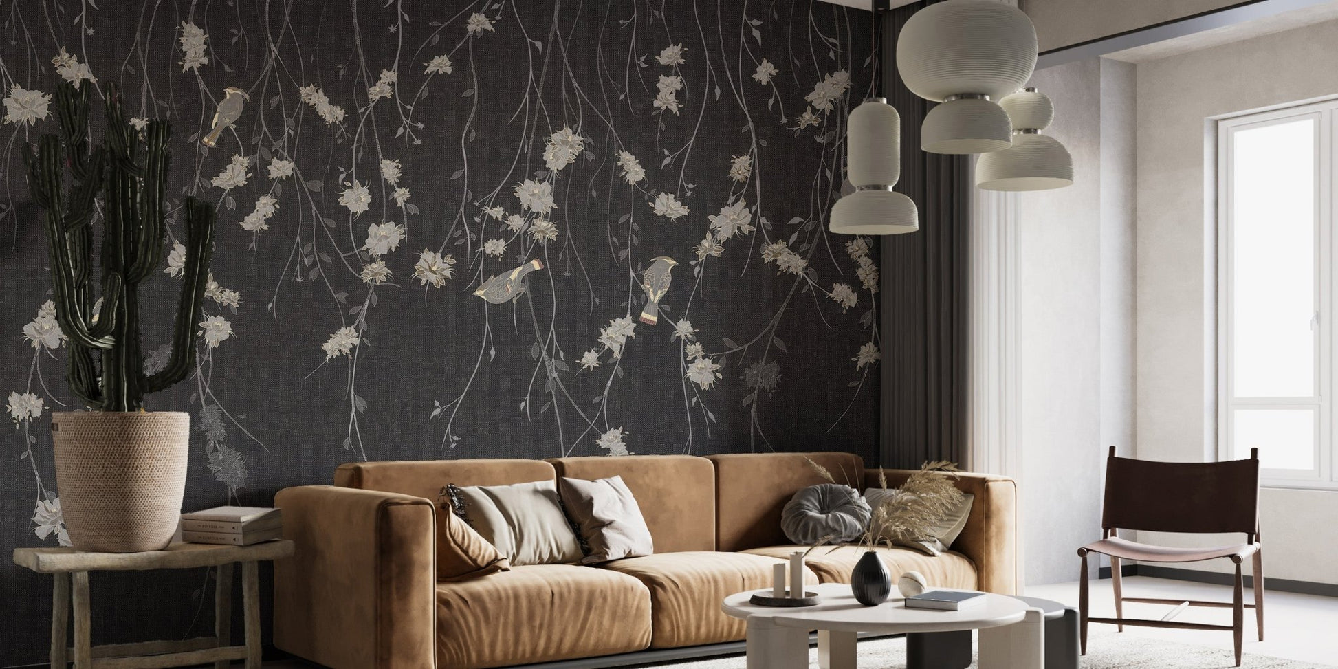 Minimalist seating area with black botanical wall mural and leather sofa.