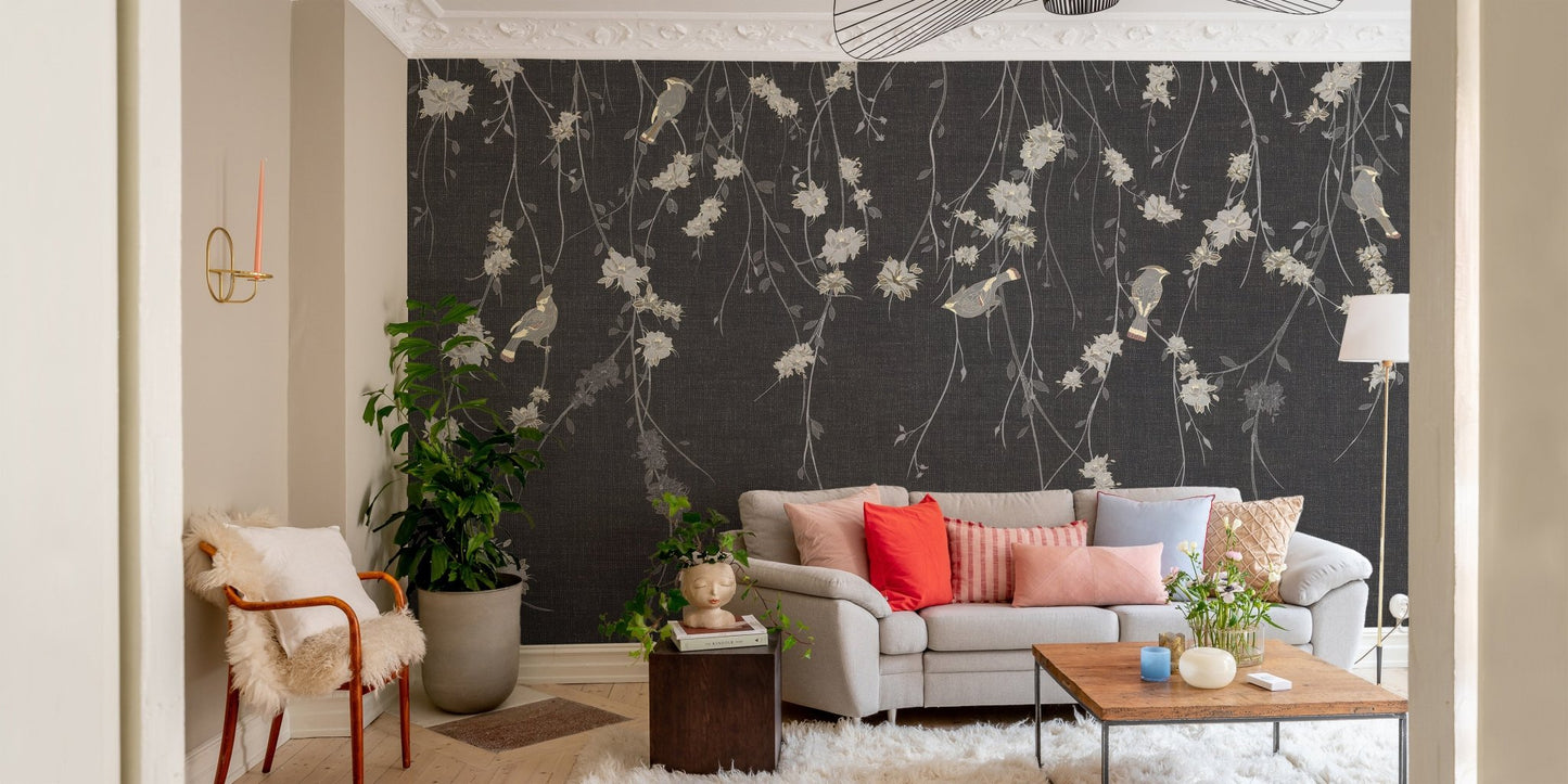 Living room with dark black flowers & birds wall mural and beige sofa.