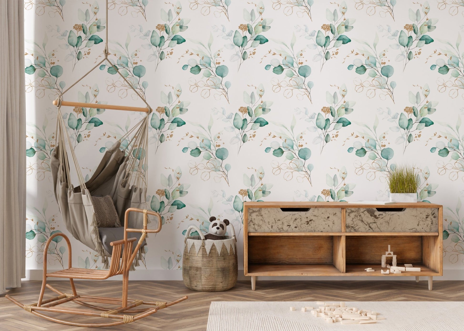Floral branch wallpaper in a nursery area with a wooden sideboard and swing chair