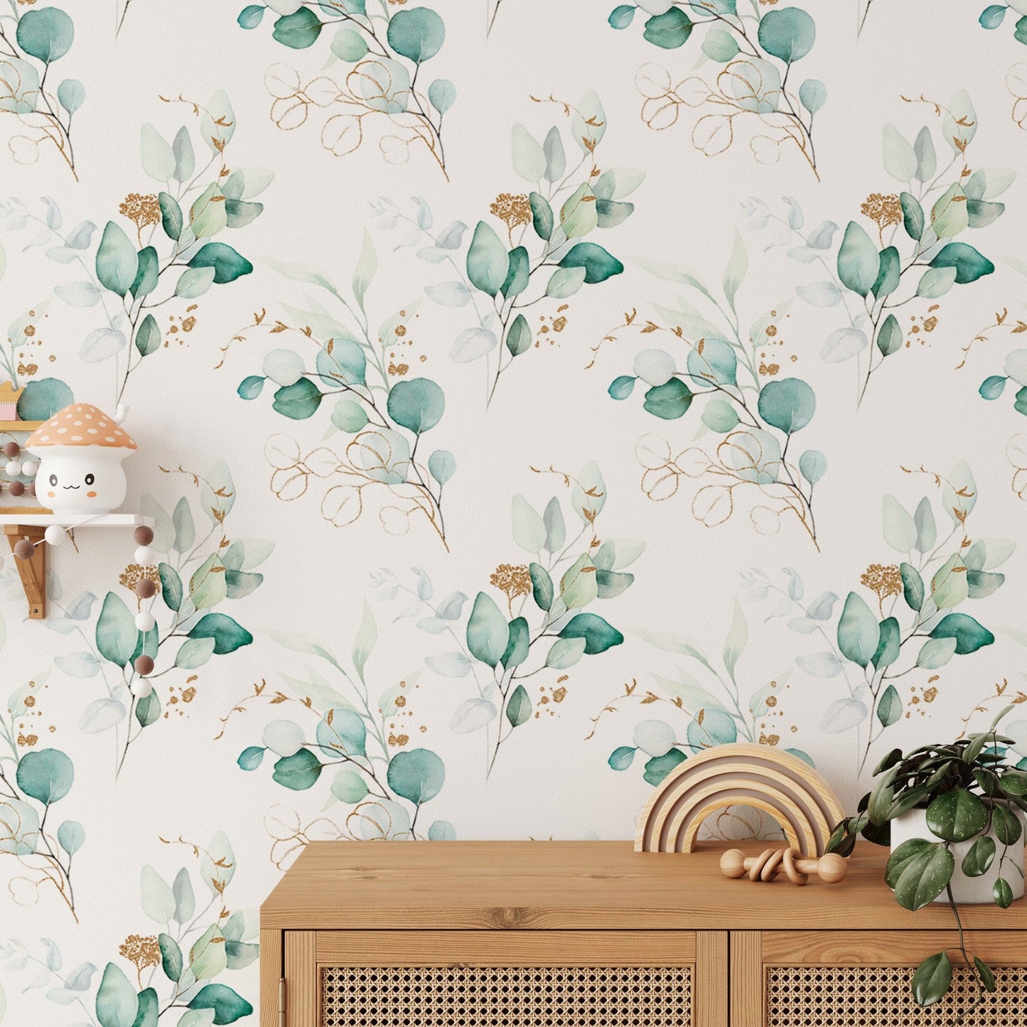Watercolor eucalyptus branches wallpaper behind a wooden cabinet with rainbow toy