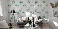 Green botanical wallpaper in a living room with a grey sofa and floor lamp