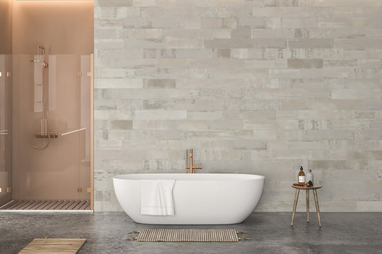 Off-white brick effect wall mural behind a white bathtub in a modern bathroom.