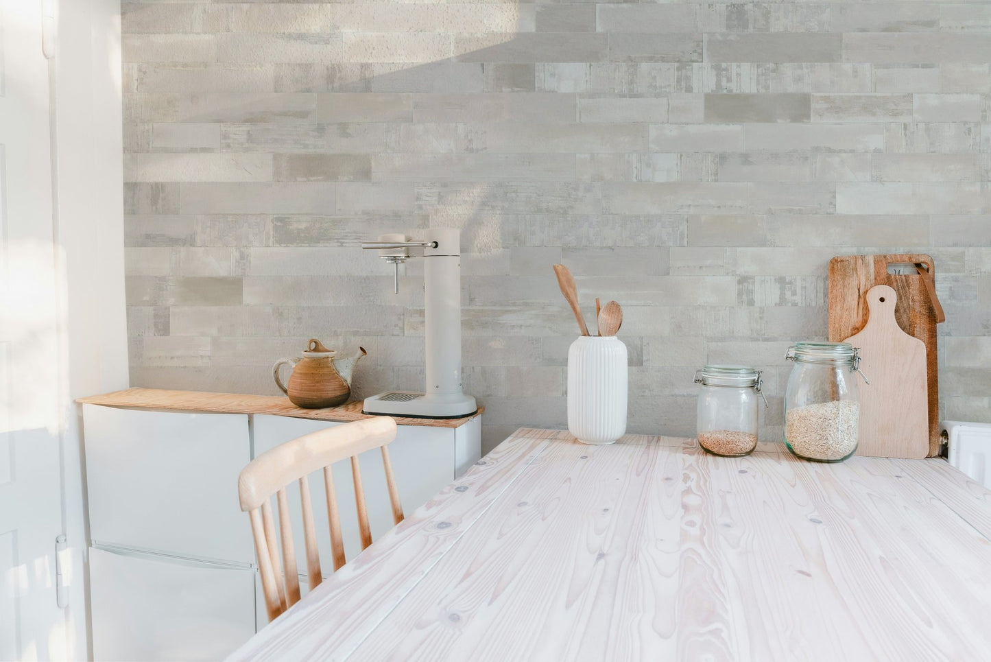 Light beige masonry wall mural in a kitchen with white cabinets