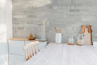 Light beige masonry wall mural in a kitchen with white cabinets