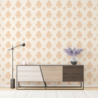 Beige classical damask repeat pattern wallpaper on a wall behind a wooden sideboard.