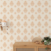 Damask pattern wallpaper on a feature wall behind a wooden cabinet and small plants.