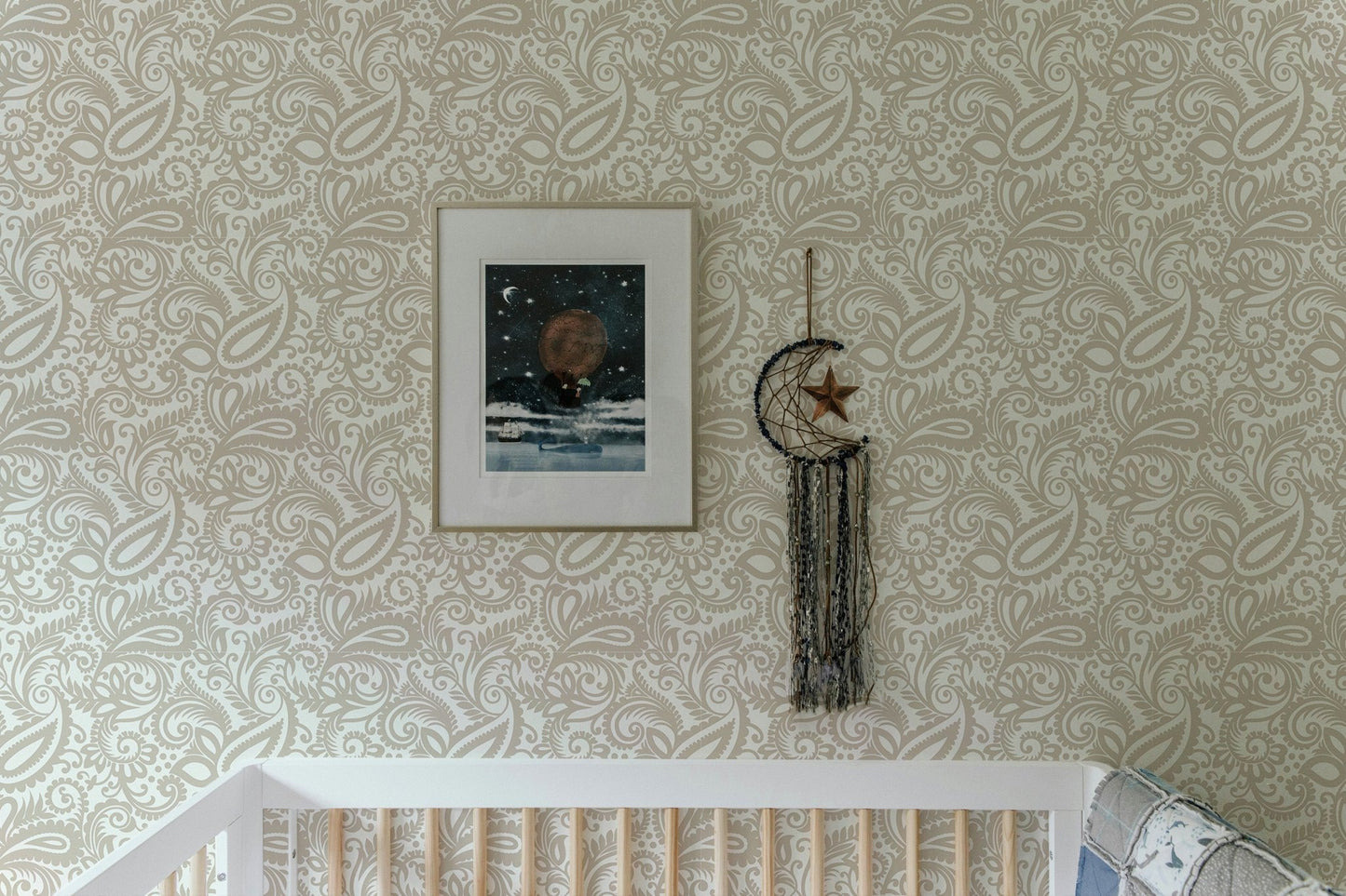 Intricate swirled leaves wallpaper in a bright nursery with a white crib.