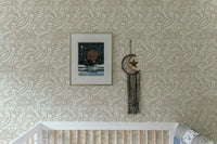 Intricate swirled leaves wallpaper in a bright nursery with a white crib.