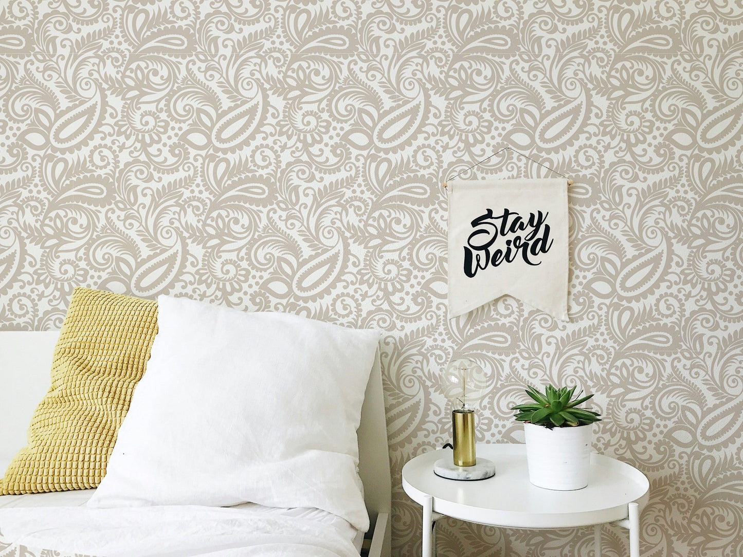Modern bedroom with white bedding and beige swirled leaves wallpaper.