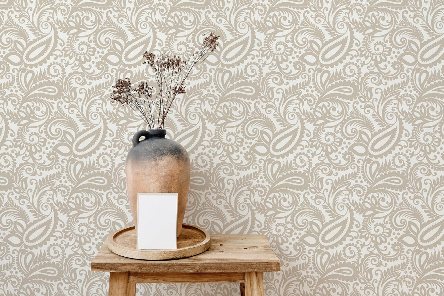 Minimalist beige paisley wallpaper used as a backdrop for wooden decor items.