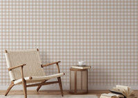 Reading nook with a wicker chair and beige scozzese stripe wallpaper.