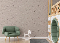 Terrazzo tiles wallpaper in playroom with green chair and white horse.