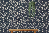 Black and white brush stroke wallpaper in a minimalist room with a wooden bench.