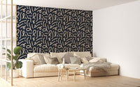 Modern abstract wallpaper behind a white sofa in a bright living room.