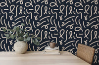 Abstract line wallpaper on a feature wall behind a wooden desk with a green plant.