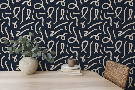 Abstract line wallpaper on a feature wall behind a wooden desk with a green plant.