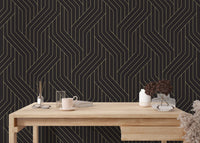 Abstract gold line wallpaper in a home office with a light wood desk.