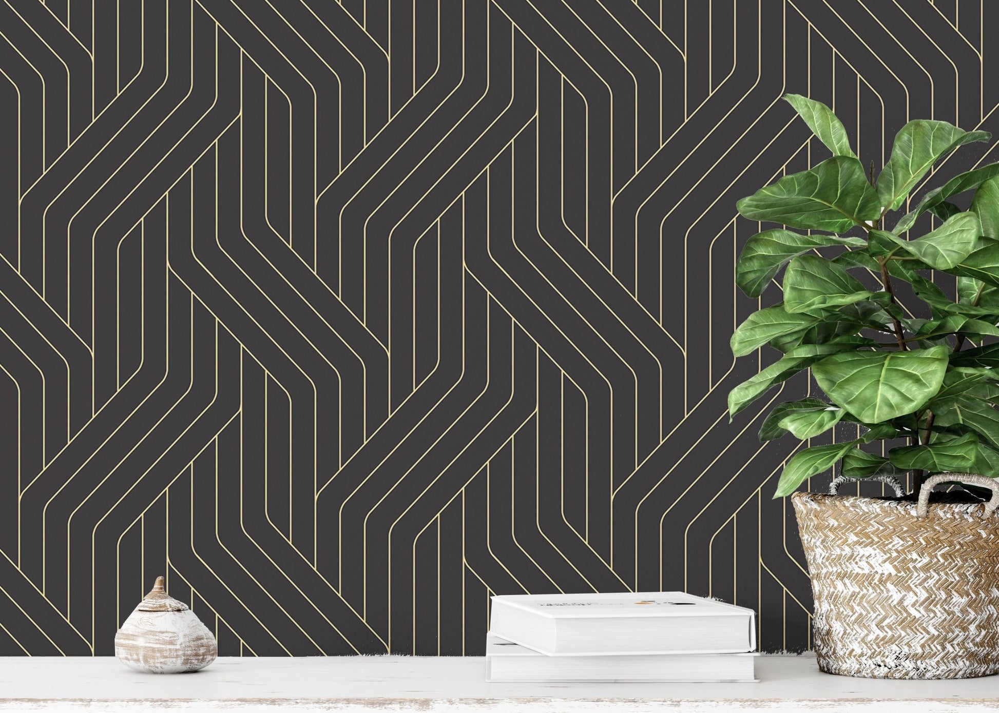 Gold geometric line wallpaper in a room with a white block and green plant.