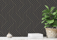 Gold geometric line wallpaper in a room with a white block and green plant.