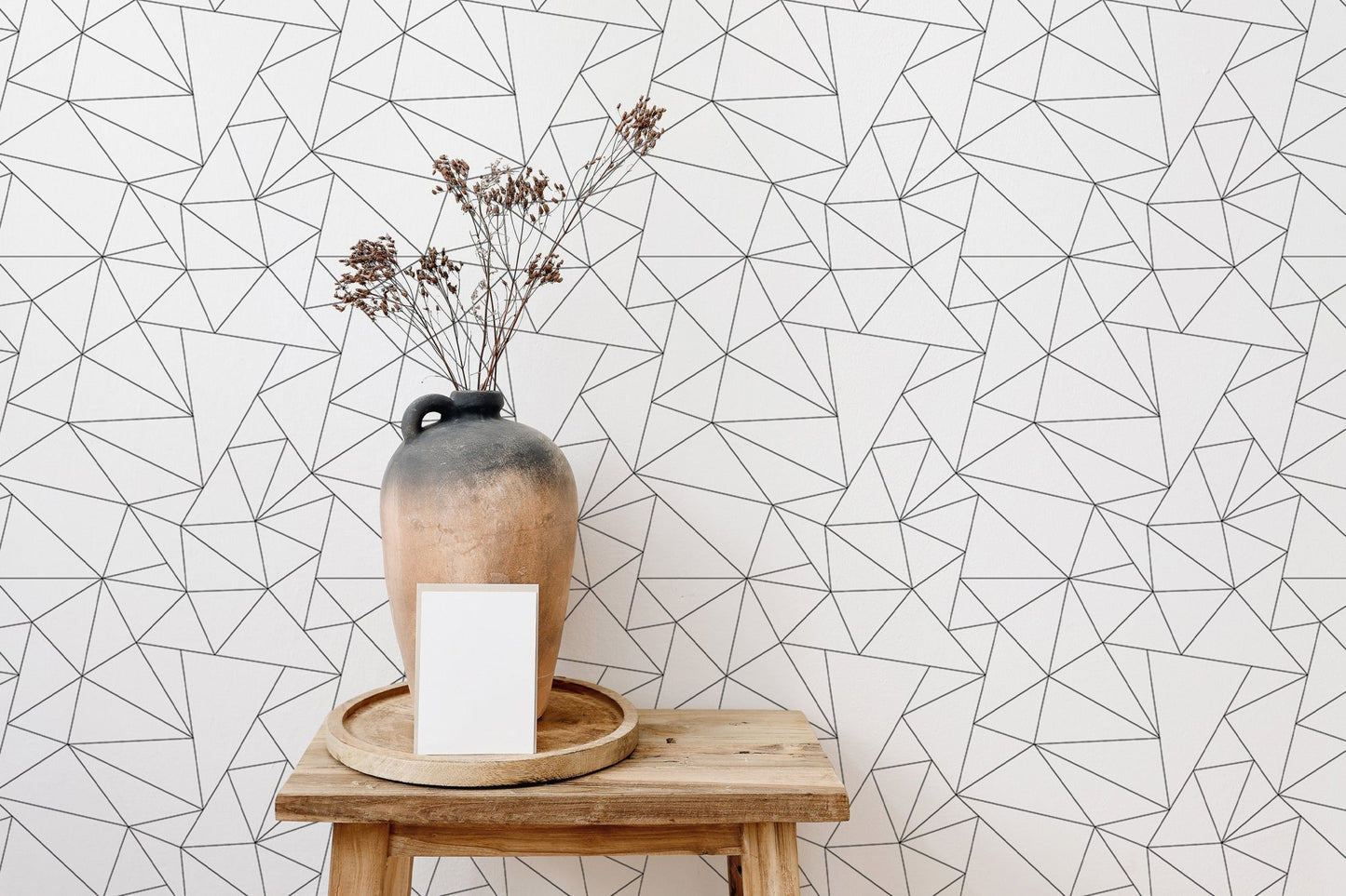 Minimalist black and white abstract wallpaper with a vase on a wooden stool.