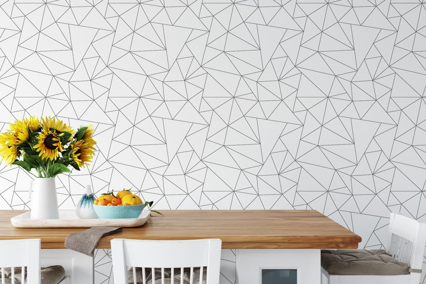 Dining table set against black and white geometric pattern wallpaper.
