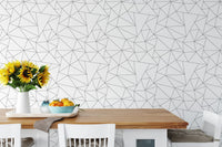 Dining table set against black and white geometric pattern wallpaper.