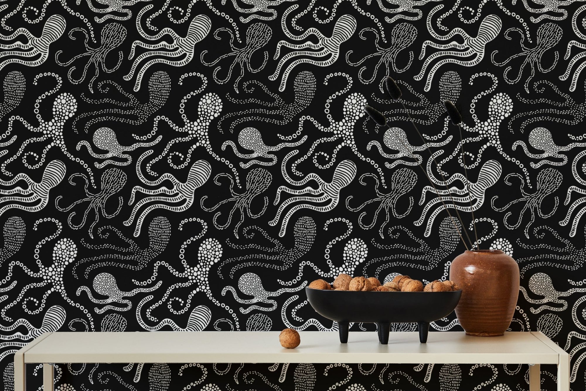 Black and white wallpaper with abstract octopus design behind dining table.