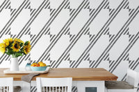Kitchen table set against a black and white diagonal stripe wallpaper.