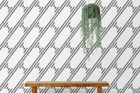 Wooden bench positioned in front of a diagonal stripe wallpaper background.