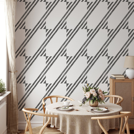 Dining room with black and white diagonal stripe wallpaper and round wooden table.