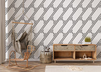 Entryway with a hanging chair and black and white diagonal stripe wallpaper.