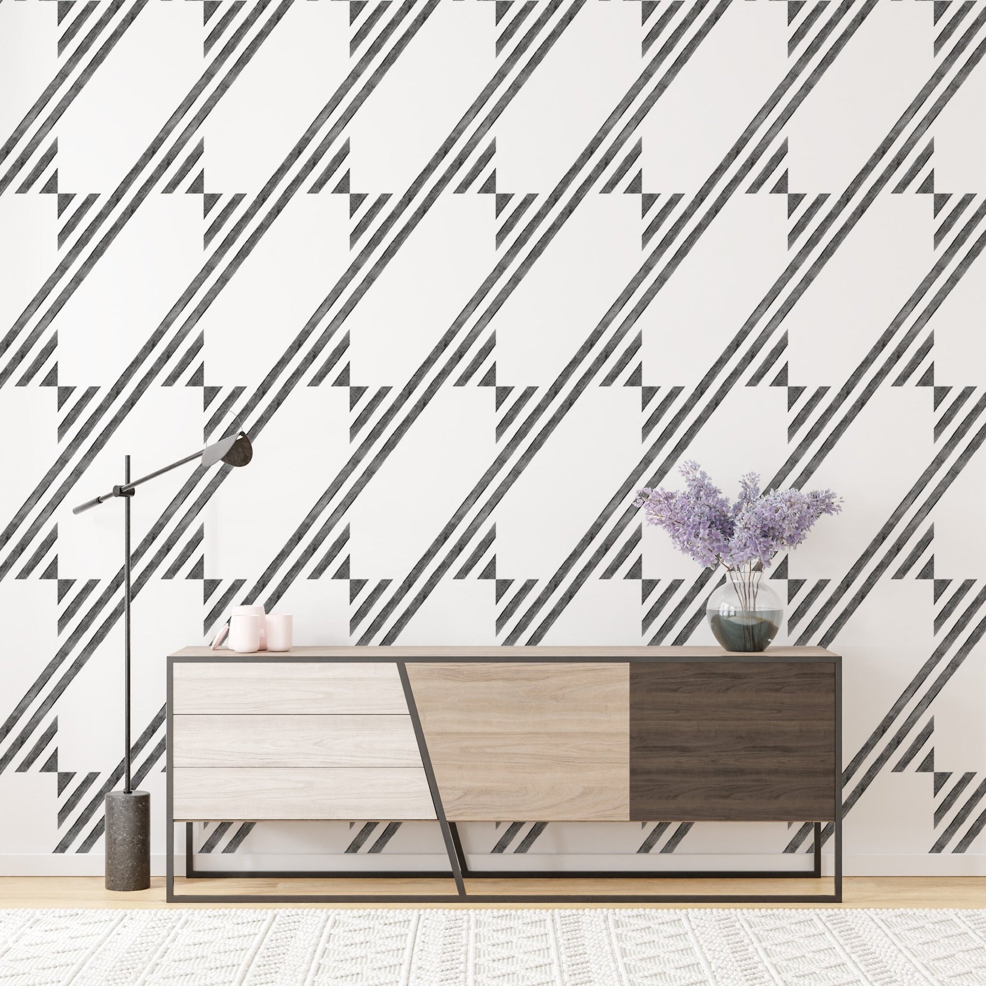 Modern sideboard placed against a geometric striped wallpaper in a bright room.