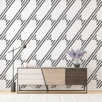 Modern sideboard placed against a geometric striped wallpaper in a bright room.
