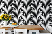 Geometric linear wallpaper in a dining area with a white table and sunflowers.