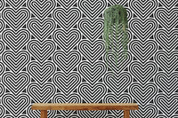 Monochrome heart wallpaper behind a wooden bench and hanging greenery.