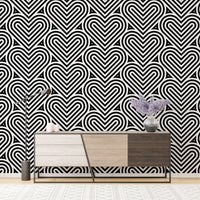 Geometric heart wallpaper behind a wooden sideboard with purple flowers.