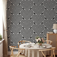 Repeating heart wallpaper in a dining room with a round wooden table.