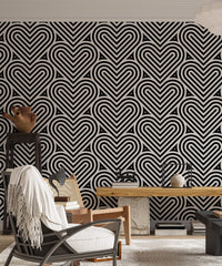 Black and white heart wallpaper in a living room with a grey chair.