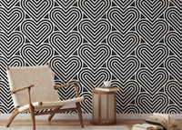 Black and white heart wallpaper in a reading area with a beige armchair.