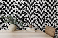 Linear heart pattern wallpaper in a workspace with a wooden desk and plant.