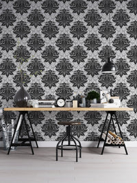 Monochrome damask wallpaper used as a backdrop for a home office desk.