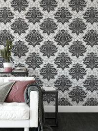 Black and white damask wallpaper in a modern living beside a white sofa.
