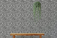Living room accent wall with geometric wallpaper behind a wooden bench.