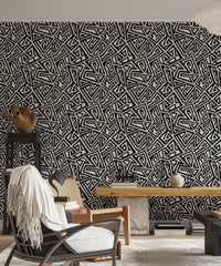 Detailed geometric wallpaper pattern in a home with a black chair.