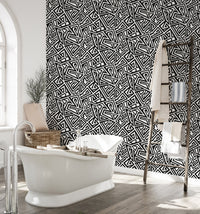 Bathroom interior featuring monochrome wallpaper behind a white freestanding tub.